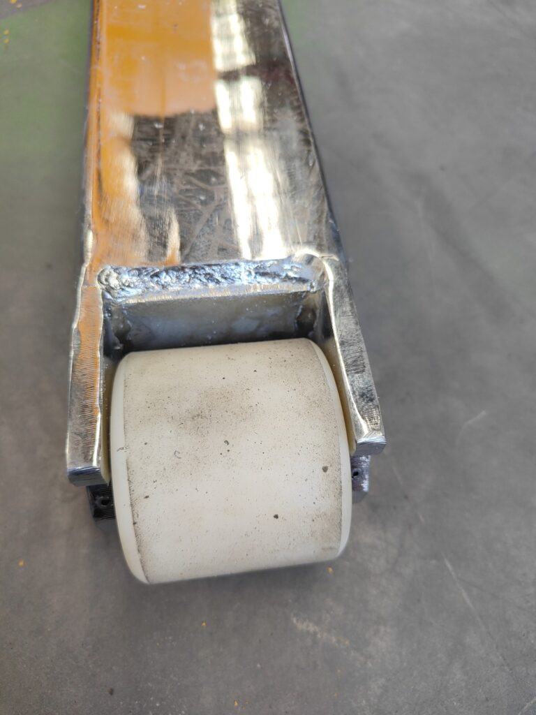 Nylon load roller at a self-loading stacker fork tip